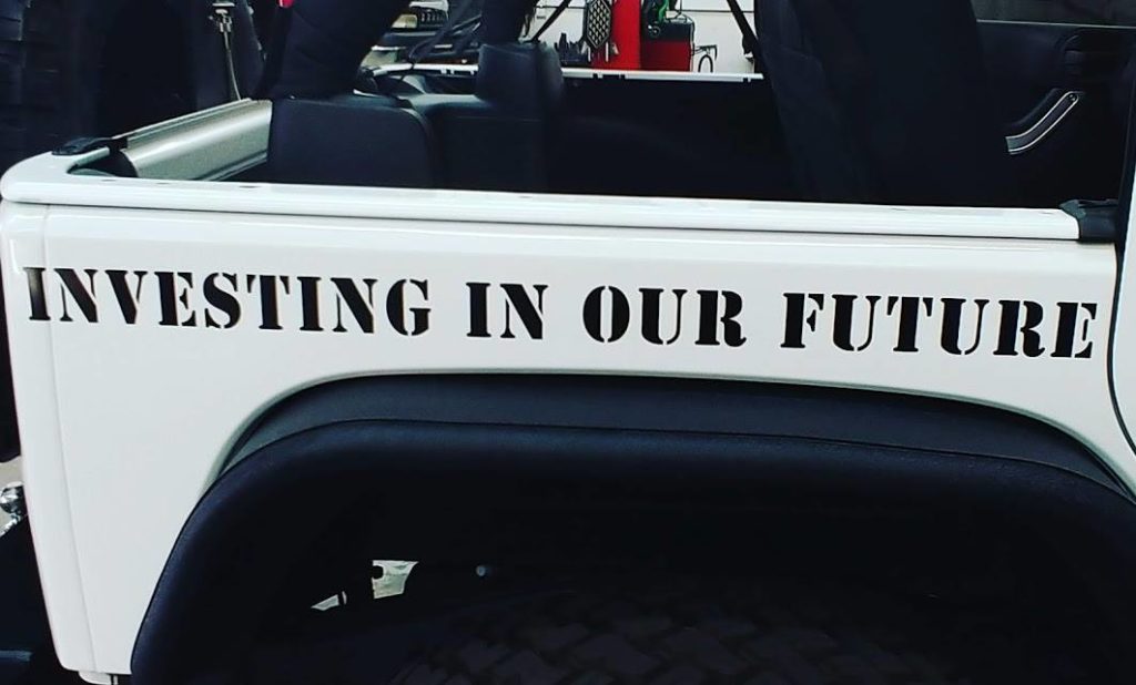 "Investing In Our Future" Stenciled onto a car